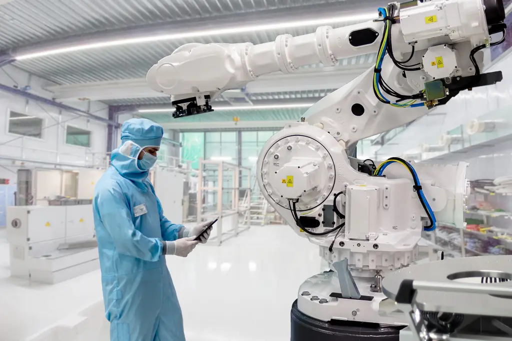 Servicetechniker im Reinraum an einem sechsachsigen Industrieroboter